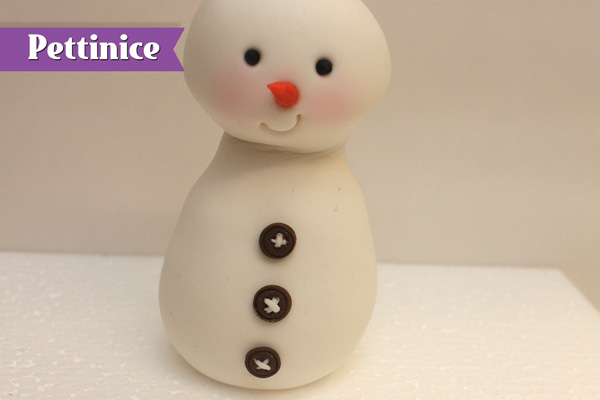 Roll very thin lines of white fondant and crisscross into the holes for thread.